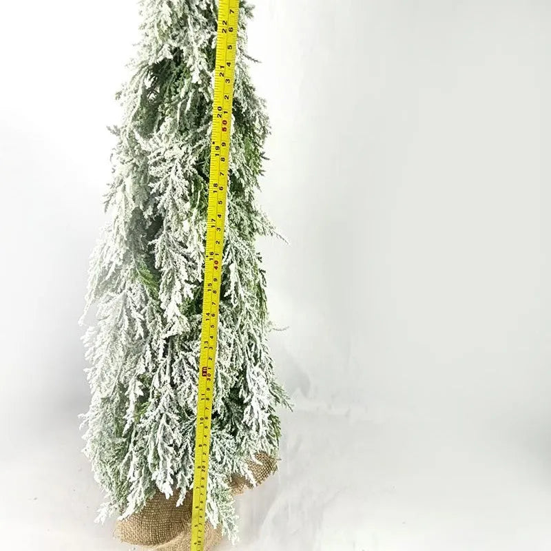 Small 24-inch white artificial Christmas tree with built-in LED lights and simulated snow sprayer on a desktop.