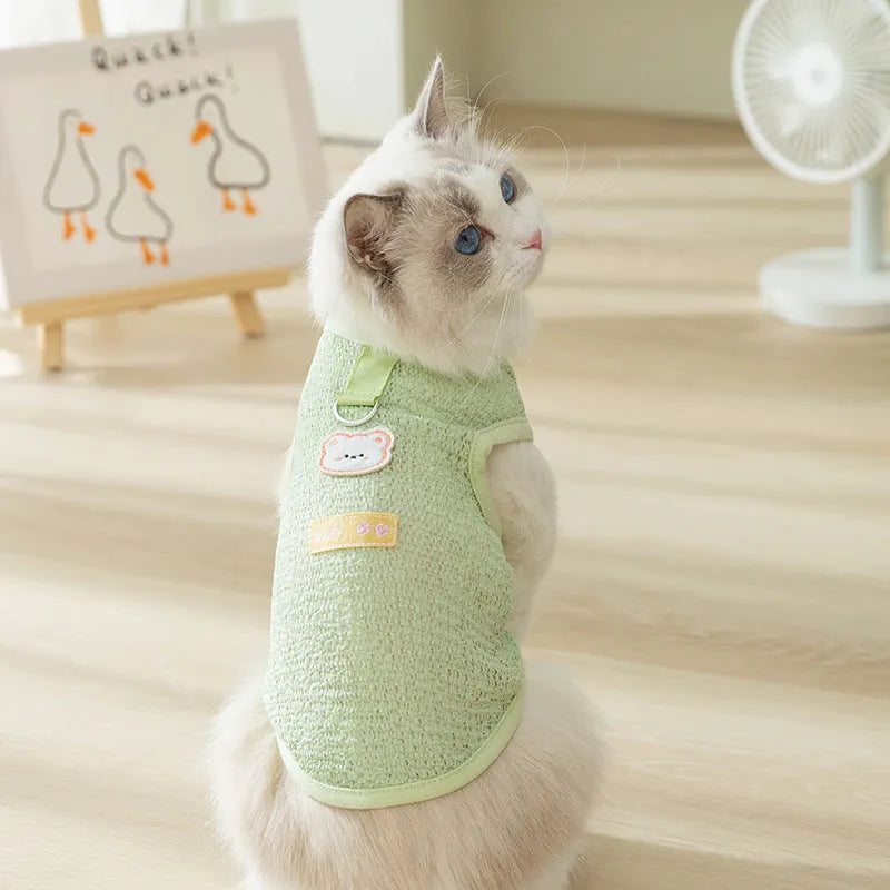 Green knitted cat clothing with bear patch design showing hollowed-out breathable fabric construction