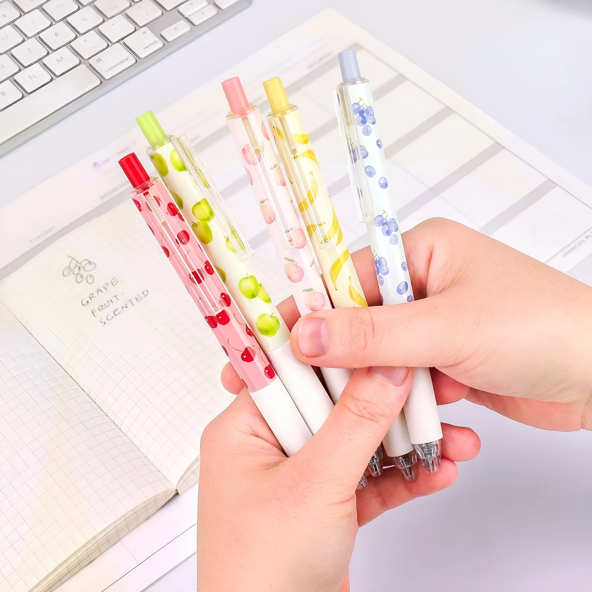Three fruit-scented gel ink pens with 0.5mm black refills and press-action click mechanism