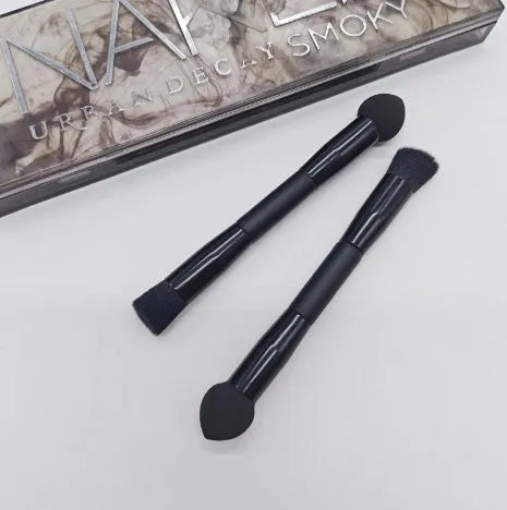 Elegant black double-headed makeup brush with a concealer brush and angled miter sponge on a wooden handle.