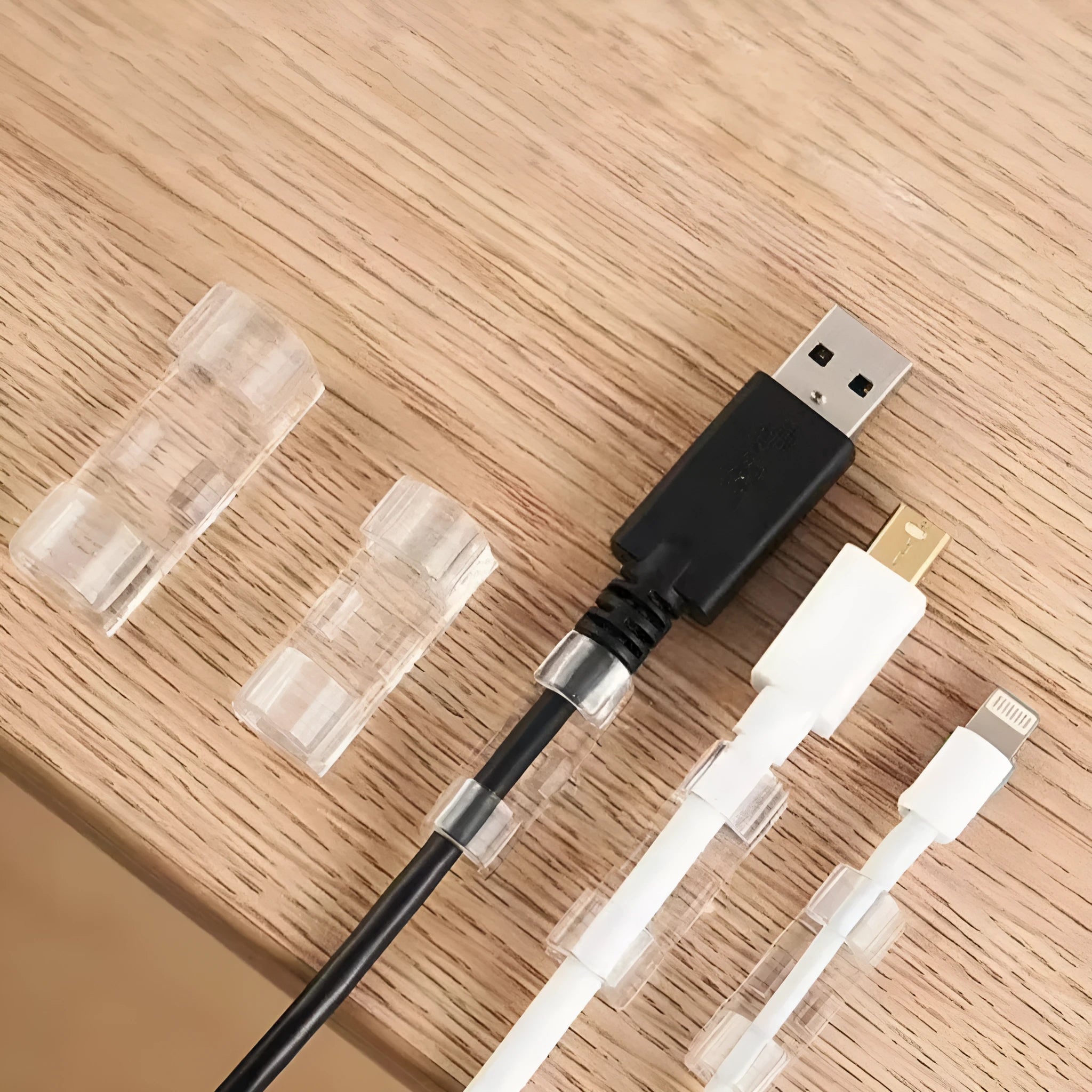 Transparent plastic self-adhesive cable clips in four size variants for wire organisation