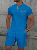 Man wearing a grey zip-front polo collar short sleeve top and matching shorts from a cotton blend suit set.