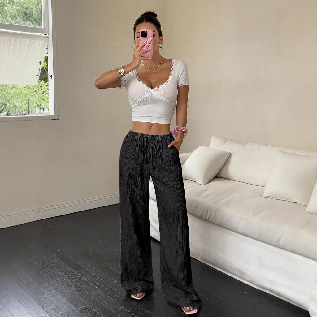 Women's wide leg casual trousers with lace-up waist detail in black and pink.