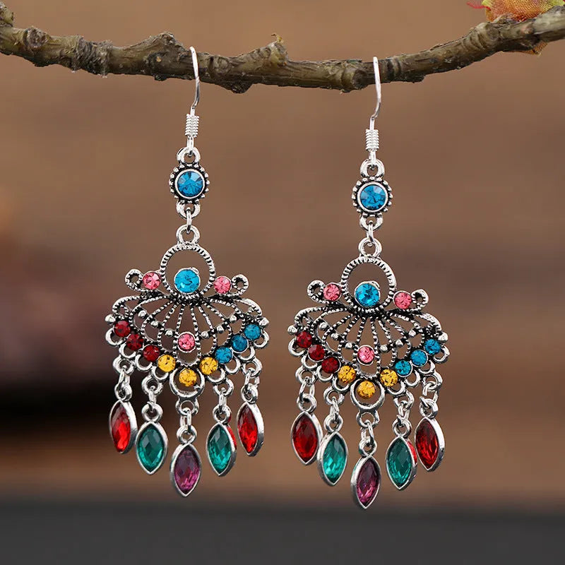 Close-up of long purple drop earrings with crystal fringe detail on an alloy setting.