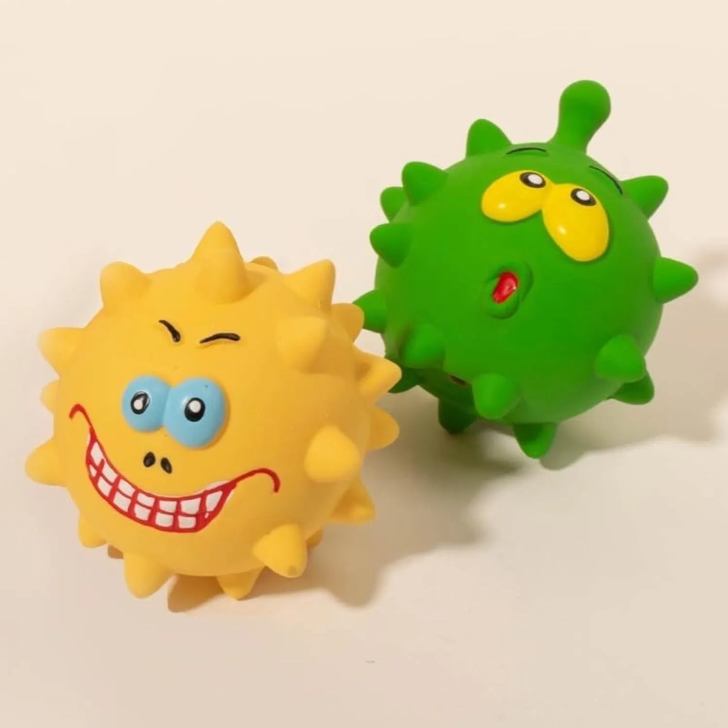 Set of four coloured squeaky dog balls with animal faces and bumpy texture