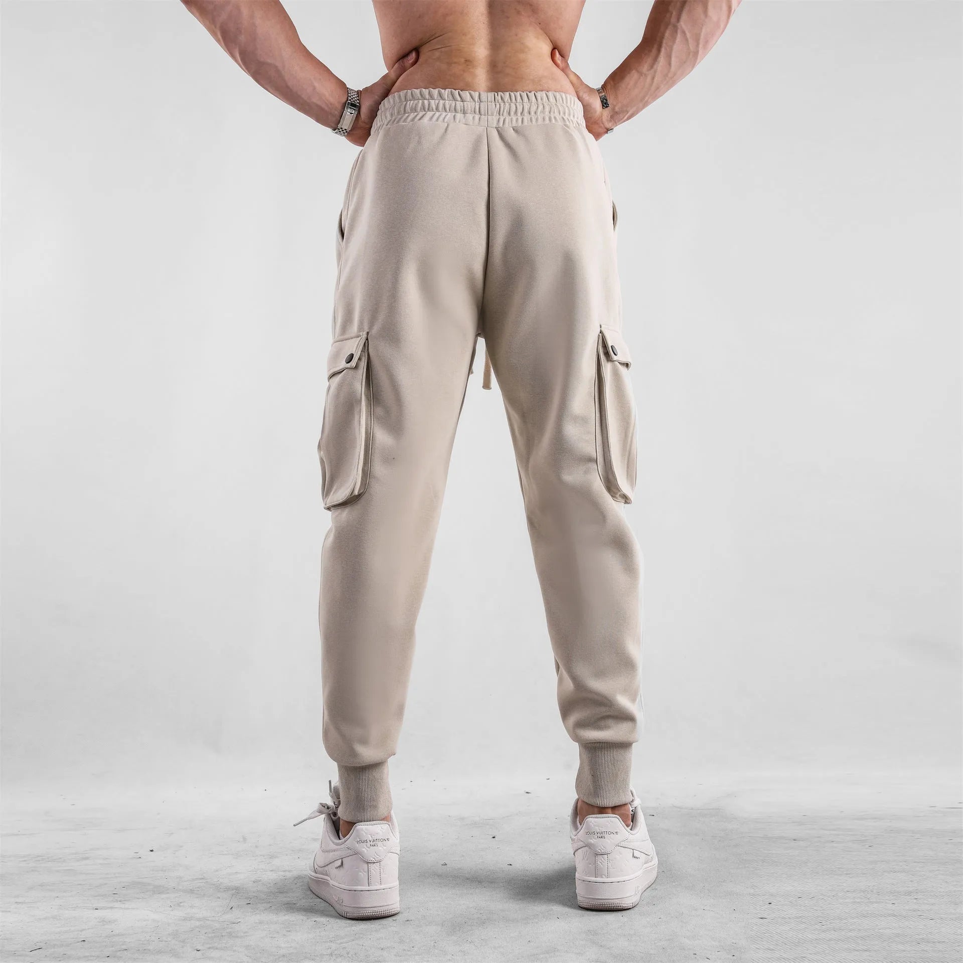 Men's loose fit multi-pocket cotton trousers with ankle ties in apricot colour