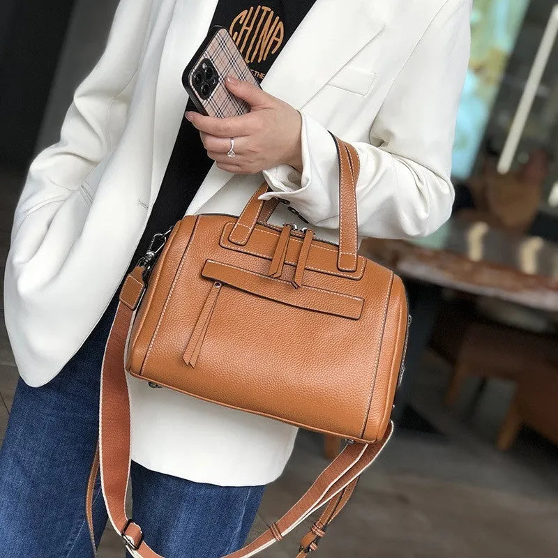 Brown genuine leather messenger bag with a textured lychee pattern, showing front flap and adjustable shoulder strap.