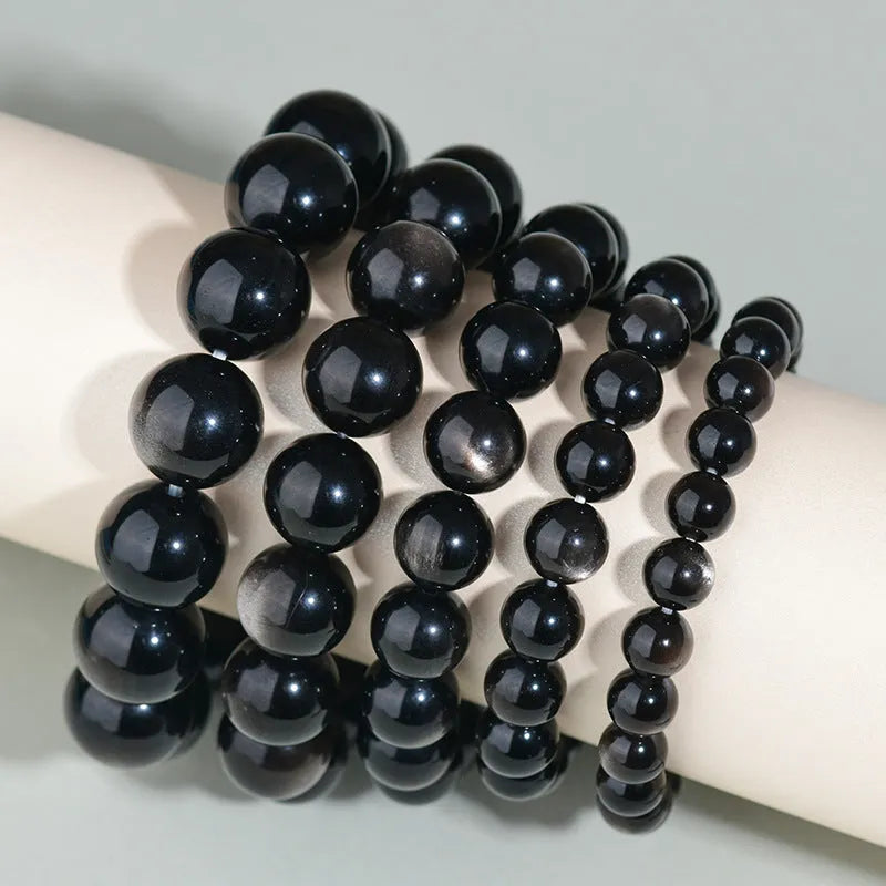 Hand-woven obsidian bracelet with round crystal beads in natural black stone