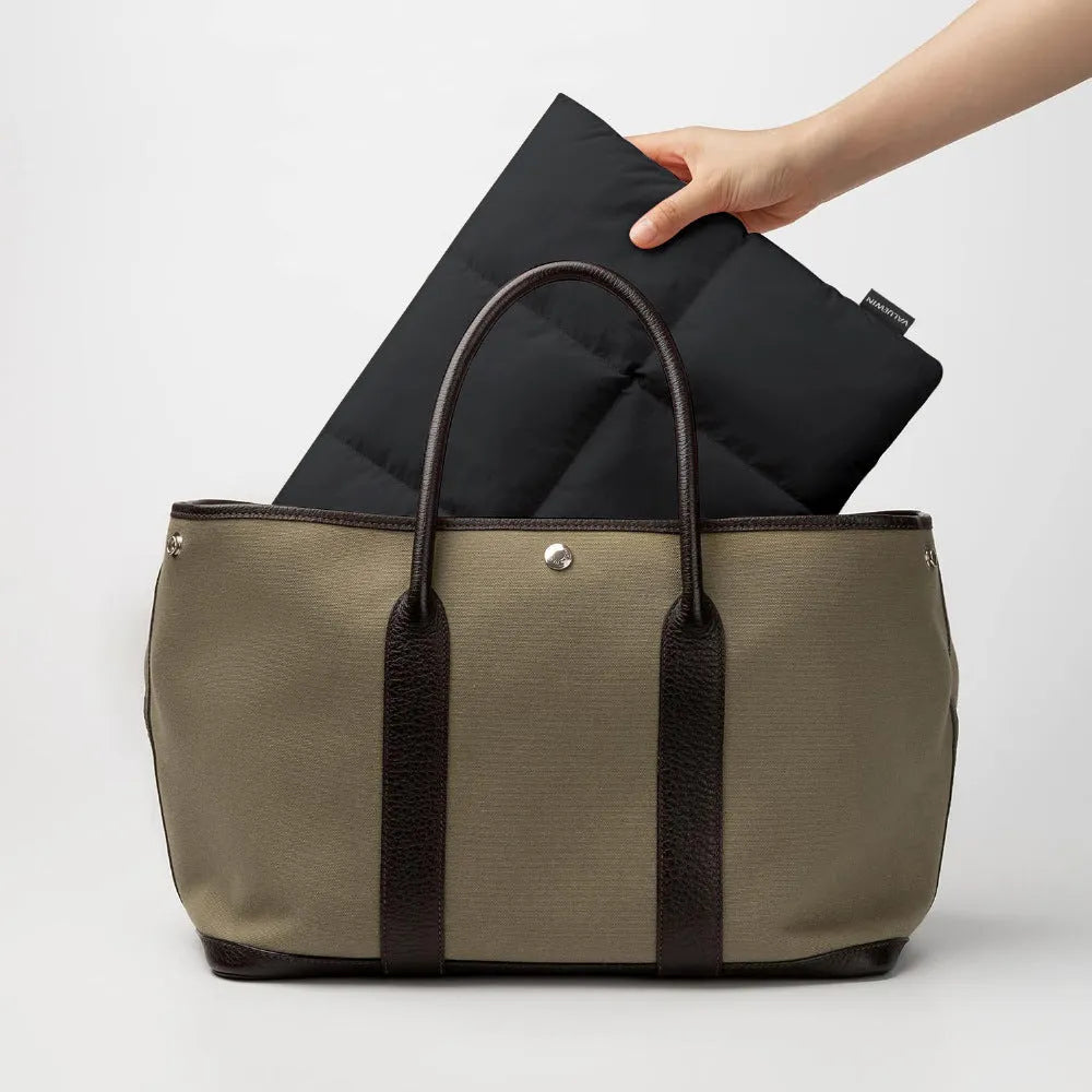 Soft black polyester laptop sleeve for a 15.6-inch laptop on a table.