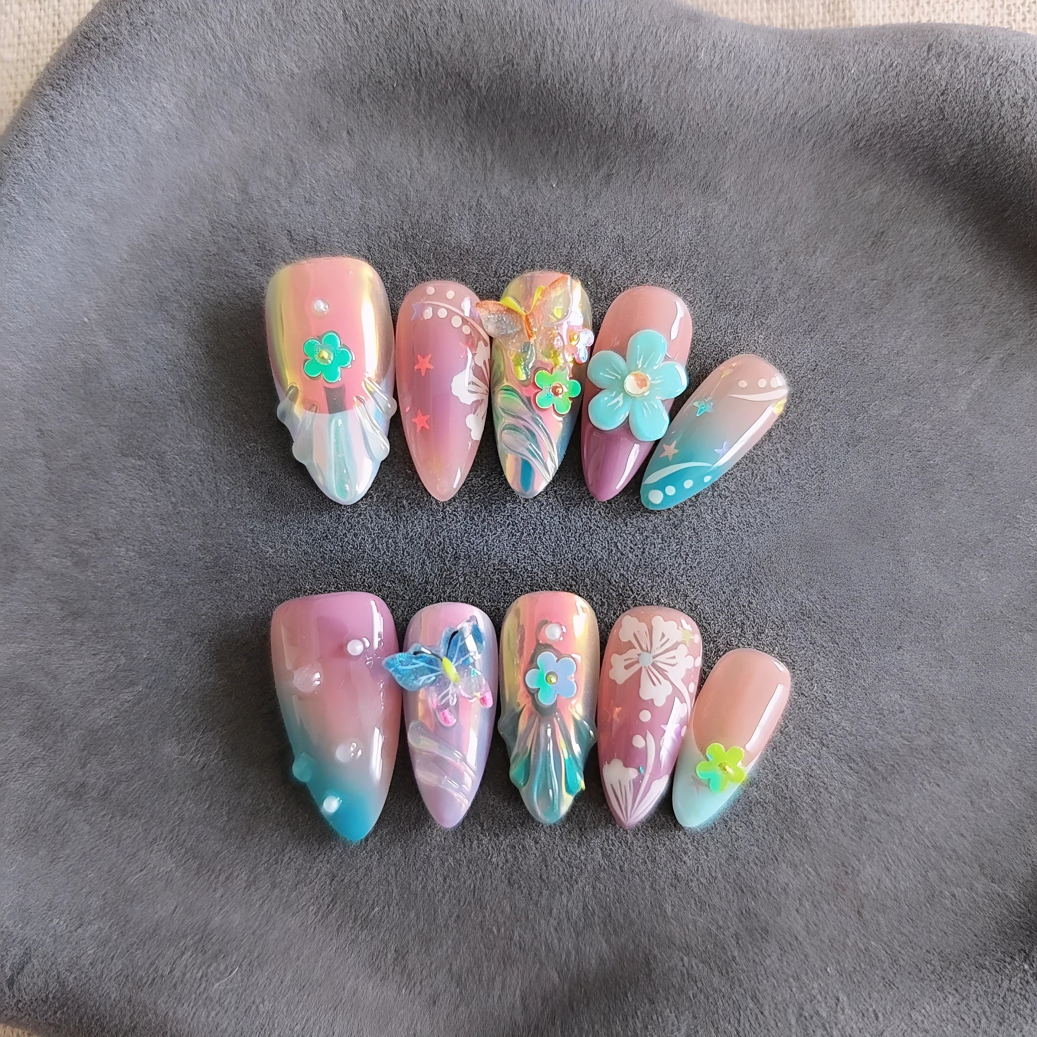Handmade acrylic press-on nails with colourful 3D embossed flower and butterfly sculptures in almond shape.