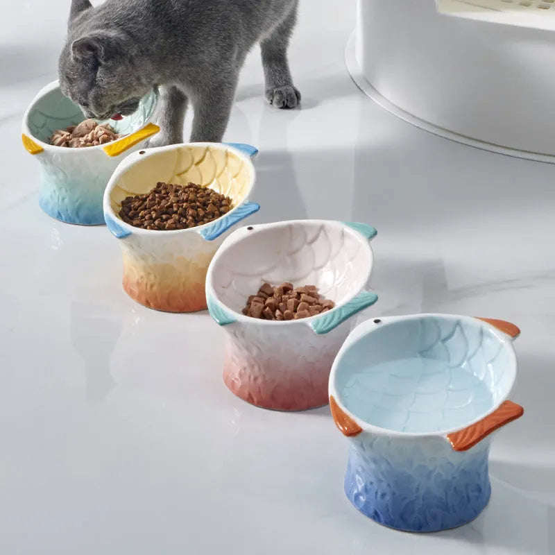 Blue fish-shaped ceramic cat bowl with elevated base and tilted food well