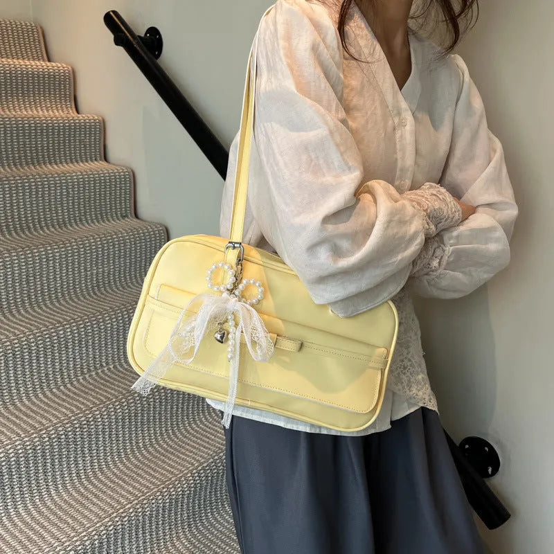 Structured PU leather single-shoulder flap bag in a horizontal square shape with a flap closure.