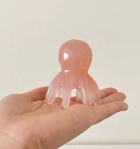 Pink octopus-shaped periocular meridian massage comb made from natural resin with storage bag