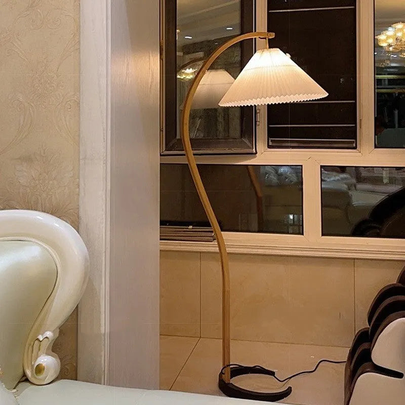 Retro vertical table lamp with fabric shade in choice of colours beside a sofa.