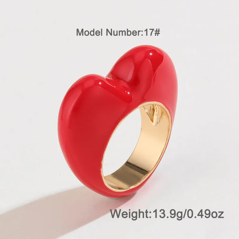 A three-dimensional heart-shaped enamel ring in zinc alloy, shown in various colours.