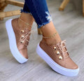 Women's white casual sneakers with decorative rivet details and round toe design