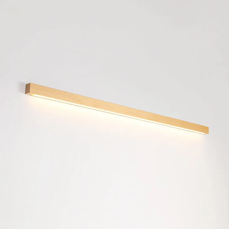 Walnut-coloured wood and acrylic minimalist LED strip wall lamp in three sizes on a white wall.