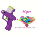 Green durable plastic battery-free cat toy launcher with a foam disc on a wooden floor.