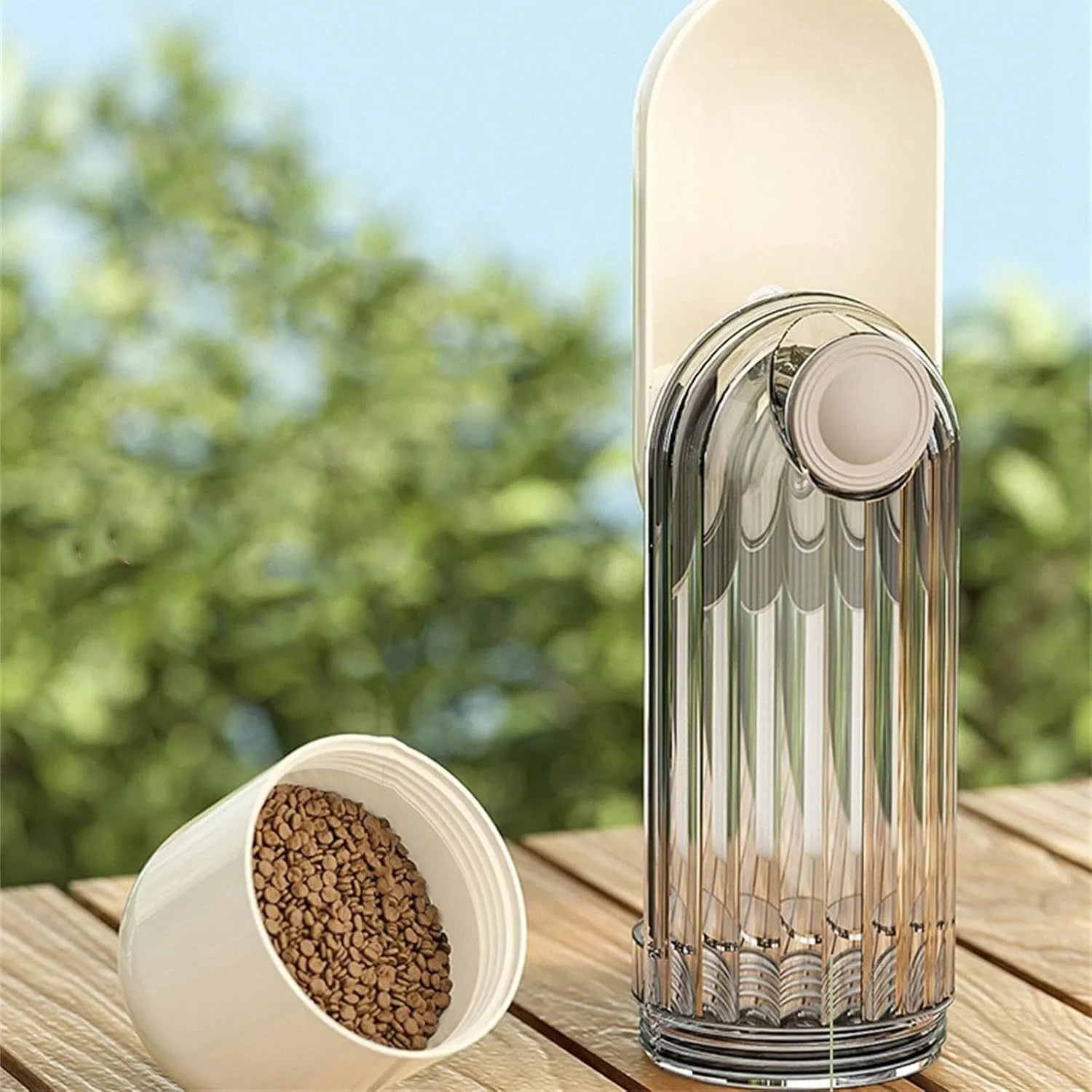 Beige foldable dog water bottle with integrated food container for outdoor walks.