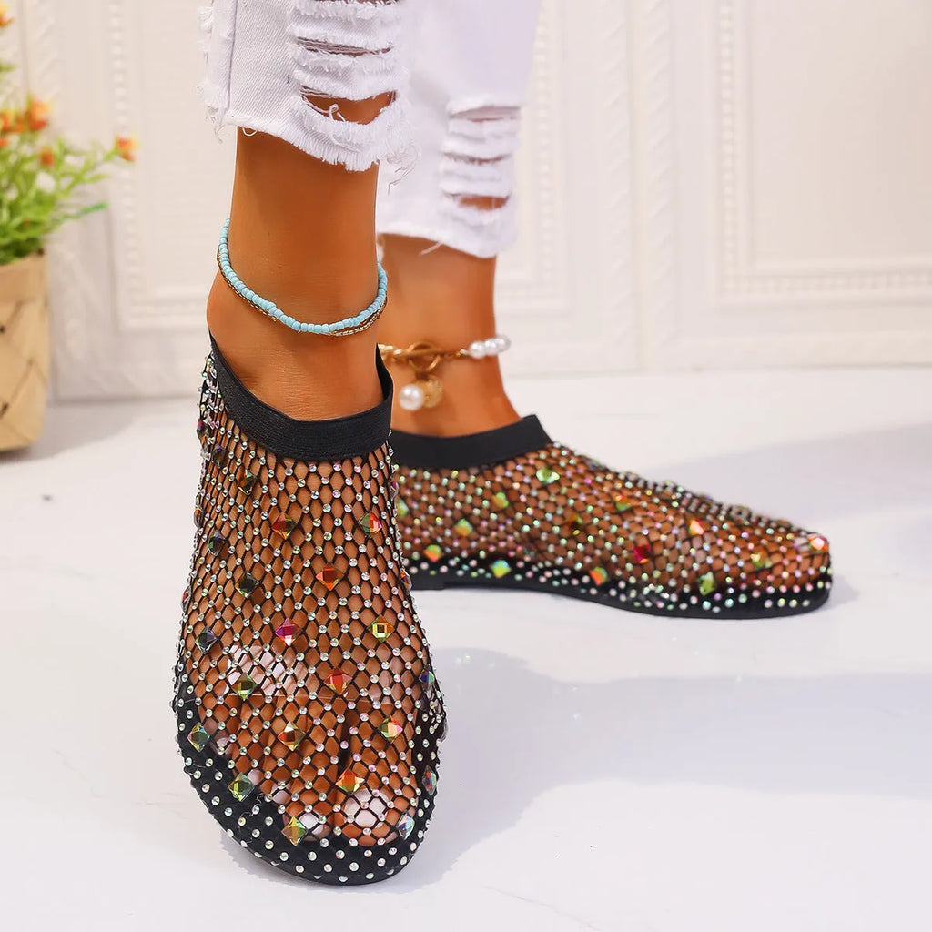 Women's white mesh flat sandals with colourful rhinestone decoration and a rubber sole.
