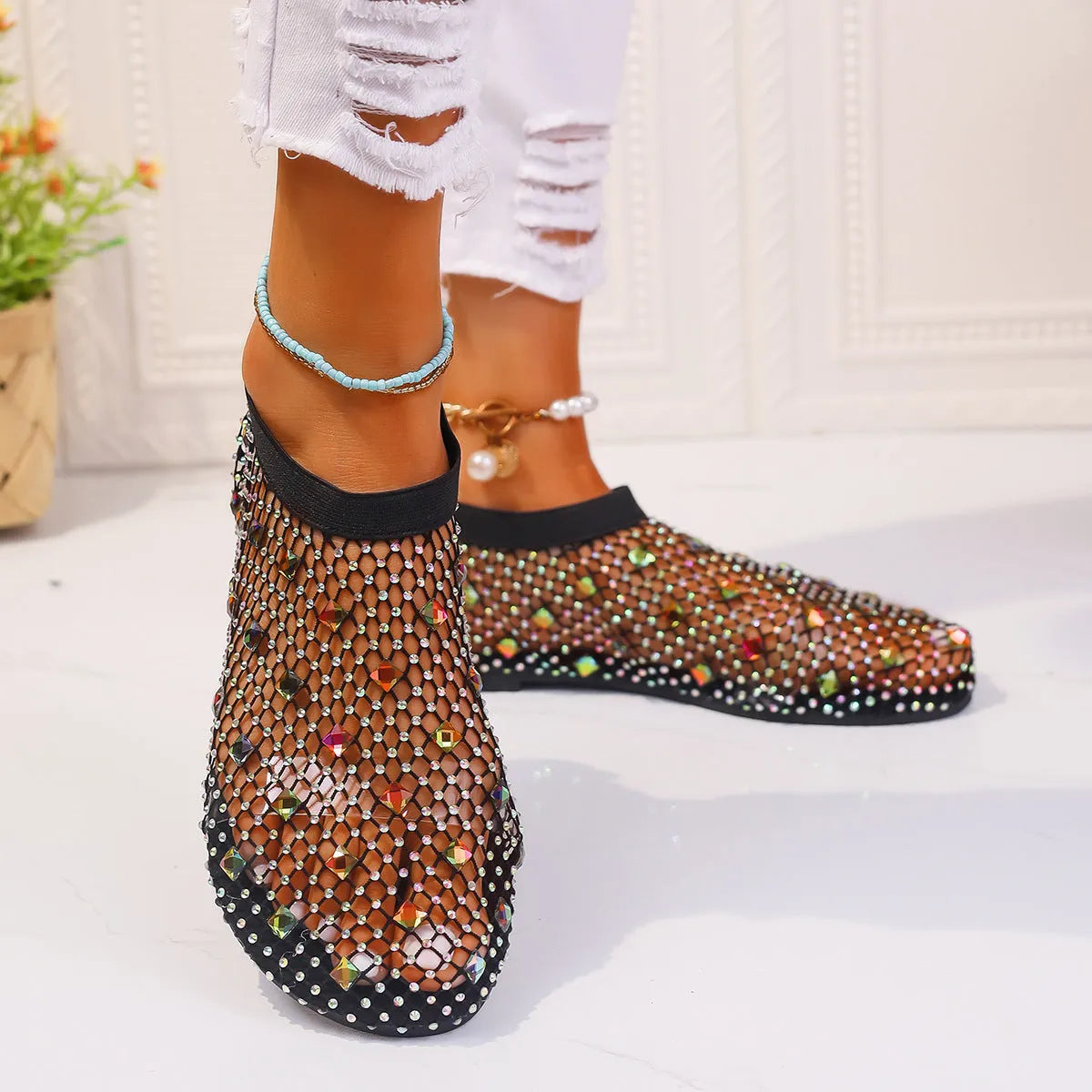 Women's white mesh flat sandals with colourful rhinestone decoration and a rubber sole.