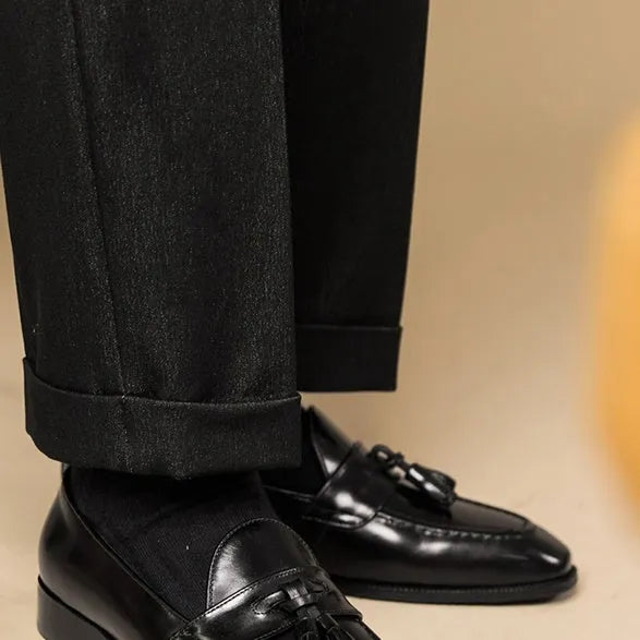 Black leather tassel loafers with polished finish and decorative tassel detail
