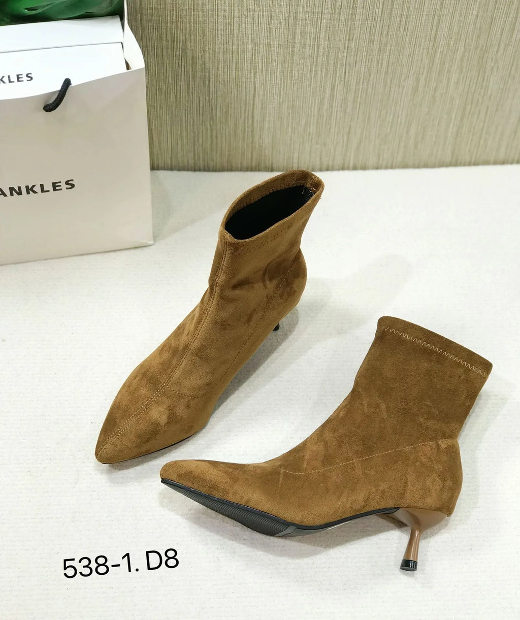 Black pointed toe women's ankle boots with a stiletto heel on a white background.