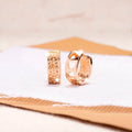 A pair of rose gold women's earrings with three hollowed-out heart shapes in a circular design.