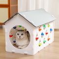 Plastic house cat scratch board with integrated tunnel containing a bell ball toy