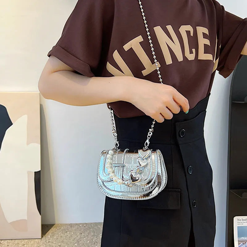 Silver square women's crossbody bag with single shoulder strap showing internal phone pocket