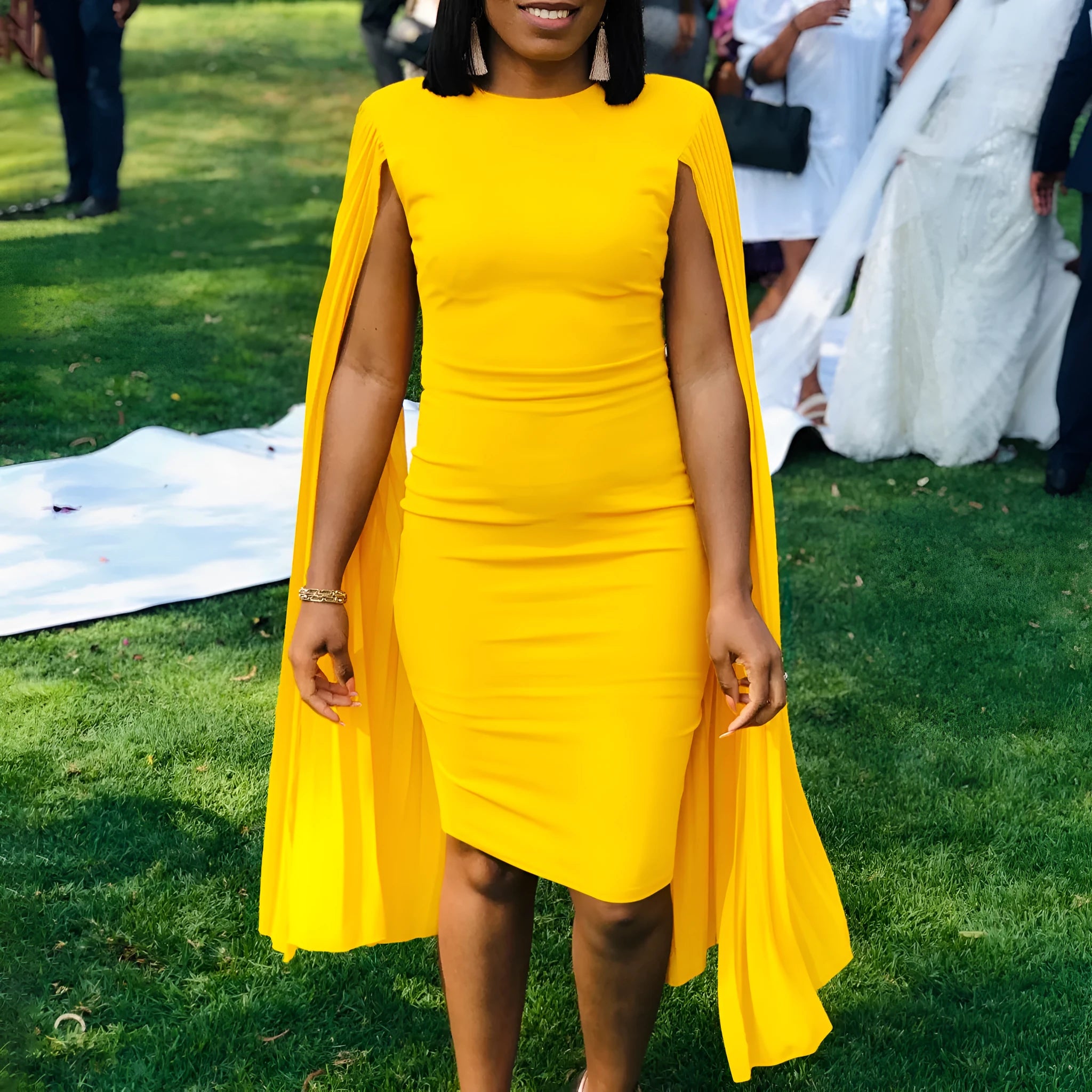 A yellow high-waist evening gown with a round neck, long sleeves, and a pleated shawl detail.