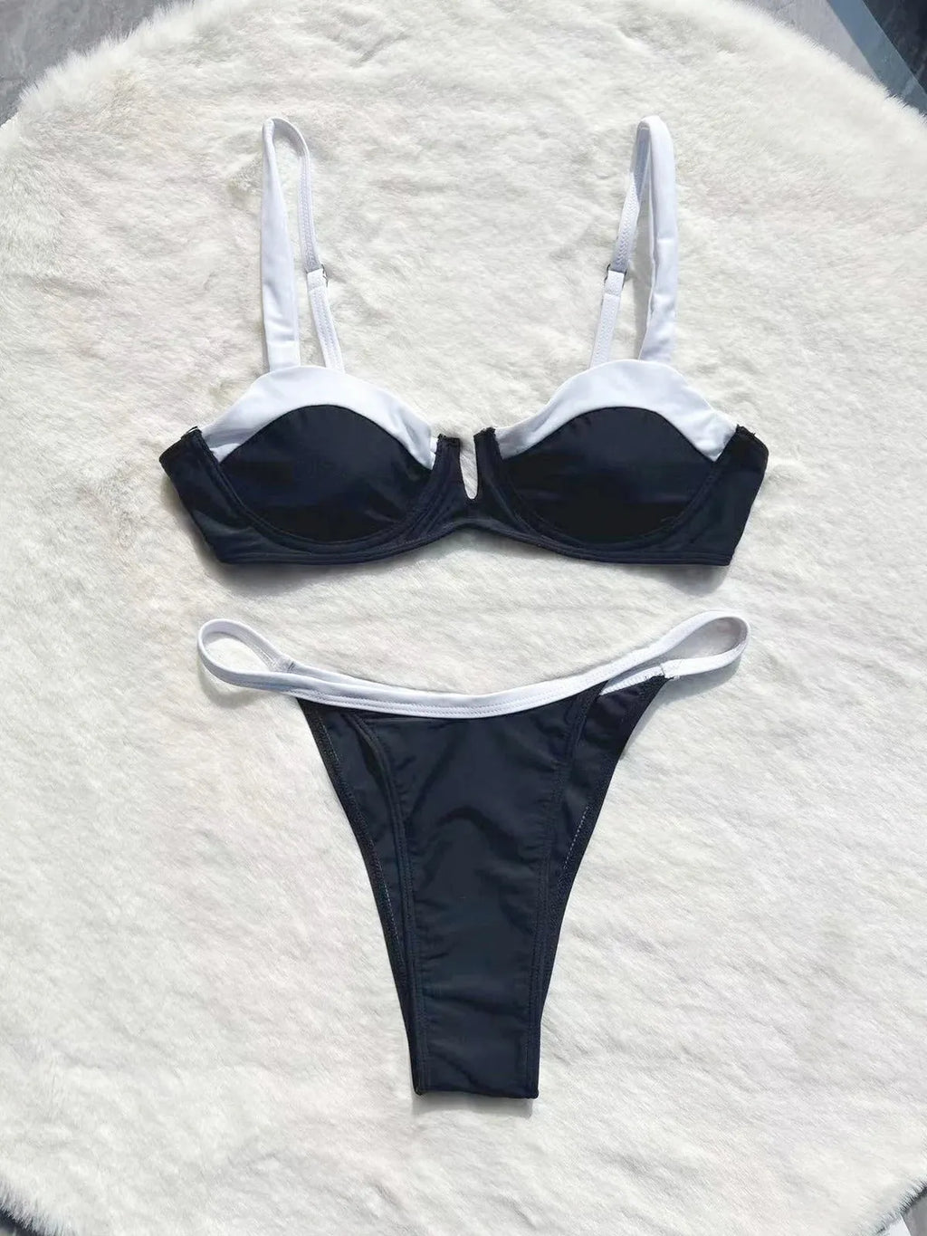 Black low waist women's bikini swimsuit with stitching split detail and briefs style.