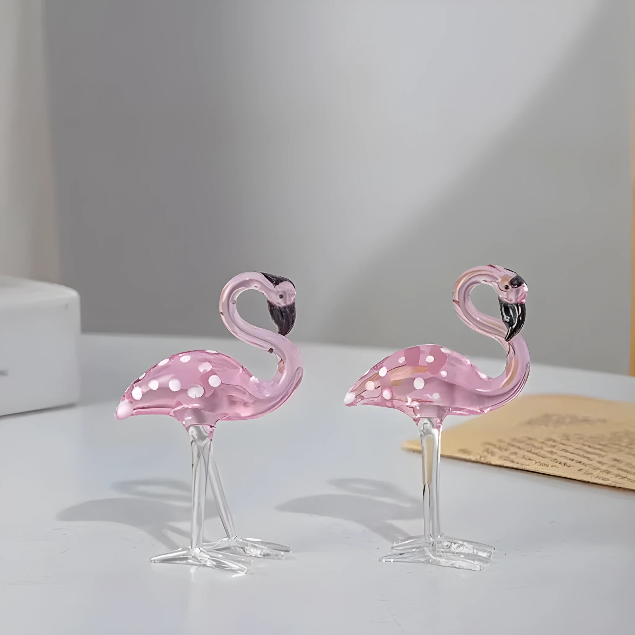 Clear crystal flamingo decorative sculpture with pink dots on a table.