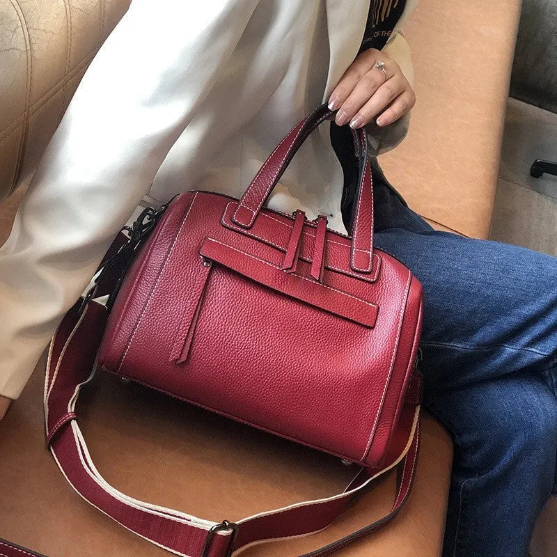 Brown genuine leather messenger bag with a textured lychee pattern, showing front flap and adjustable shoulder strap.