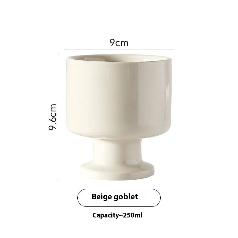 A handmade, irregularly shaped ceramic mug in a solid colour, shown on a table.