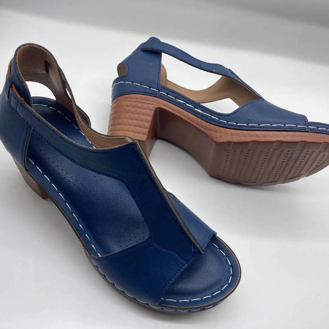 Women's beige peep toe wedge sandals with an adjustable ankle buckle strap on a foot.