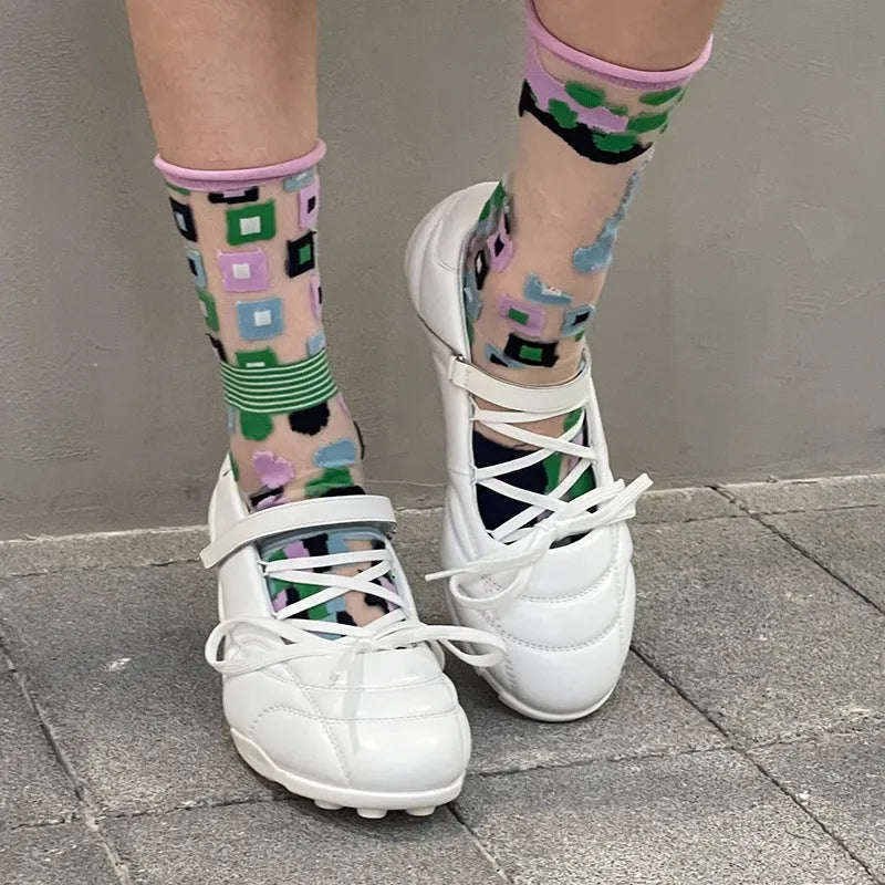 Women's silver lace-up sports shoes with a bow detail and a mid-height heel on a white background.