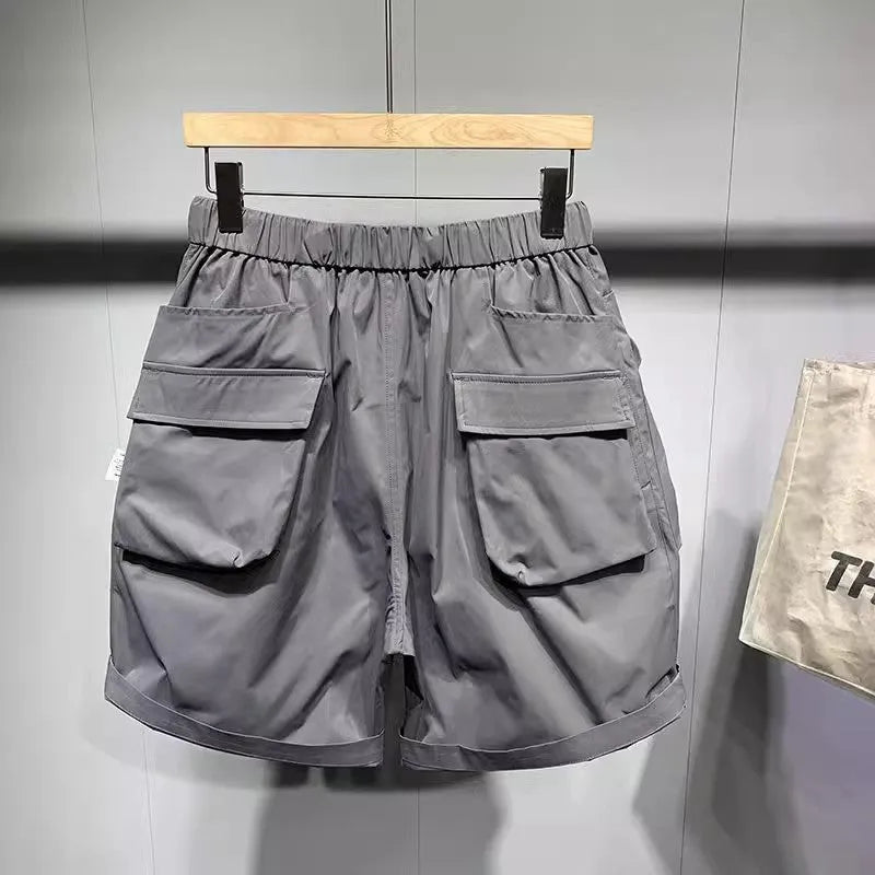 Men's loose fit black work shorts with pockets, shown on a model