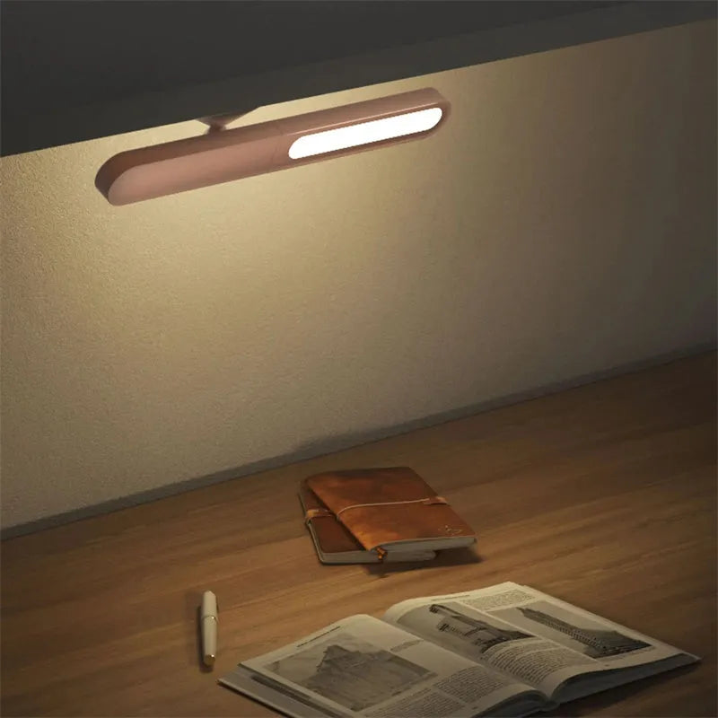White geometric desk lamp with USB cable and magnetic base for wall mounting.