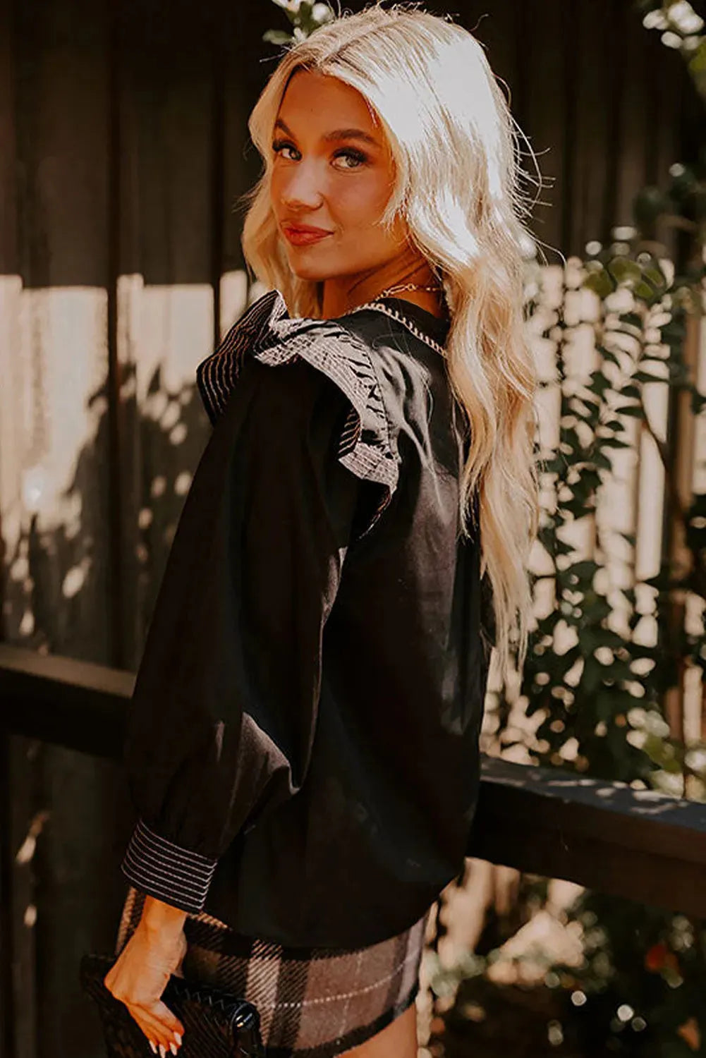 Black women's V-neck long sleeve blouse with ruffle detail and contrast stitching