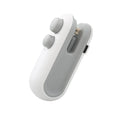 White and blue handheld USB heat sealer with cutter blade on a kitchen counter.