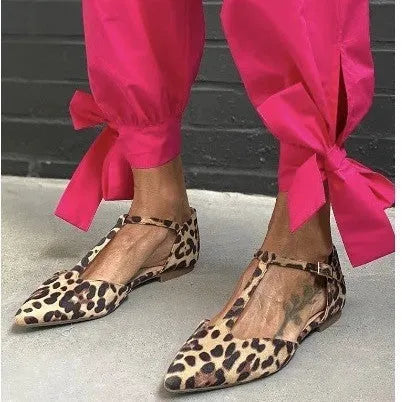 Leopard print women's pumps with a pointed toe, cross straps, and a chunky low heel.