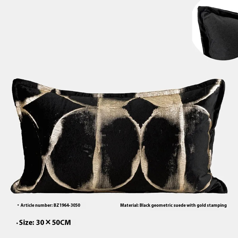 Black gold abstract patterned square decorative pillow with a soft flannel texture on a grey sofa.