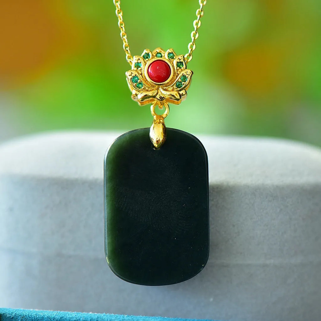 Flat grey Hetian jade pendant with copper metal inlay and small ink blue jade accents on a necklace chain.