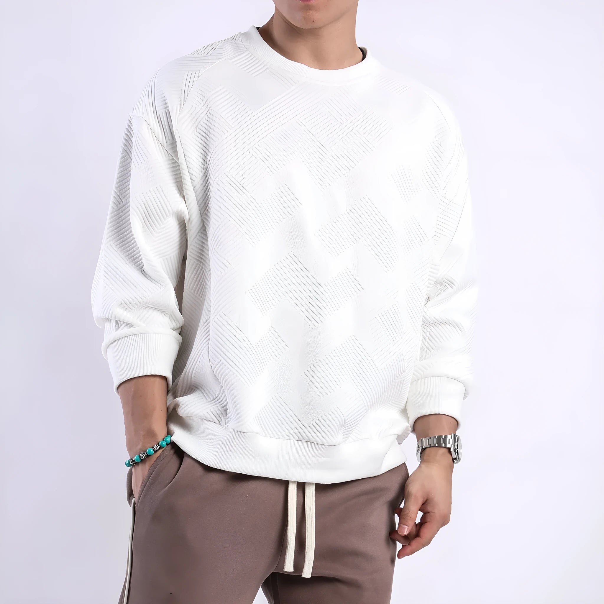 Man wearing a loose-fit, long-sleeved twill jacquard sweater in a solid colour with a round neck.