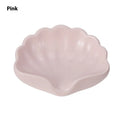 White or pink plastic shell-shaped soap dish for bathroom countertops.