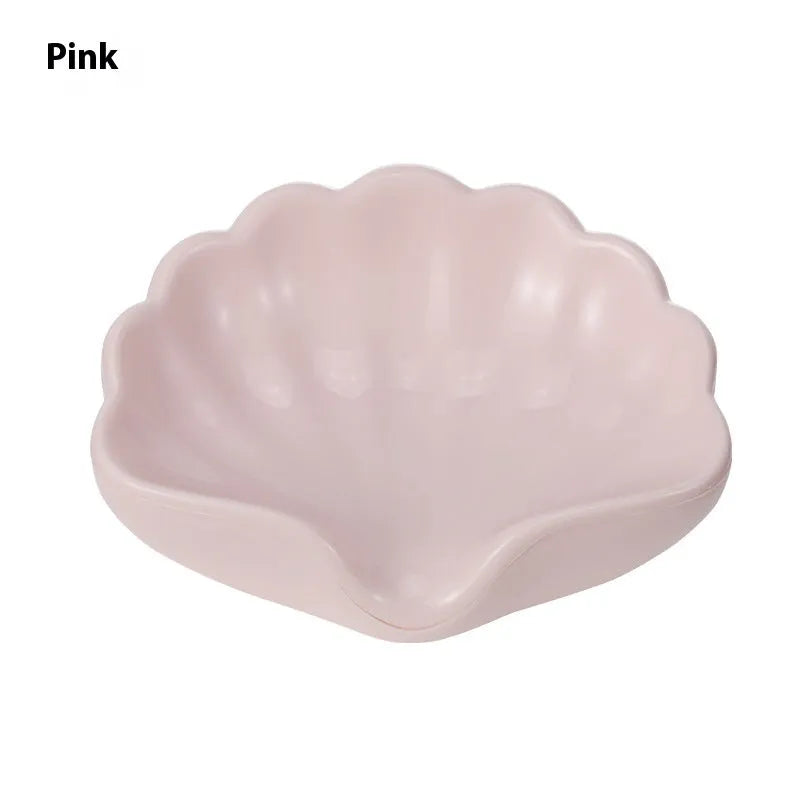 White or pink plastic shell-shaped soap dish for bathroom countertops.