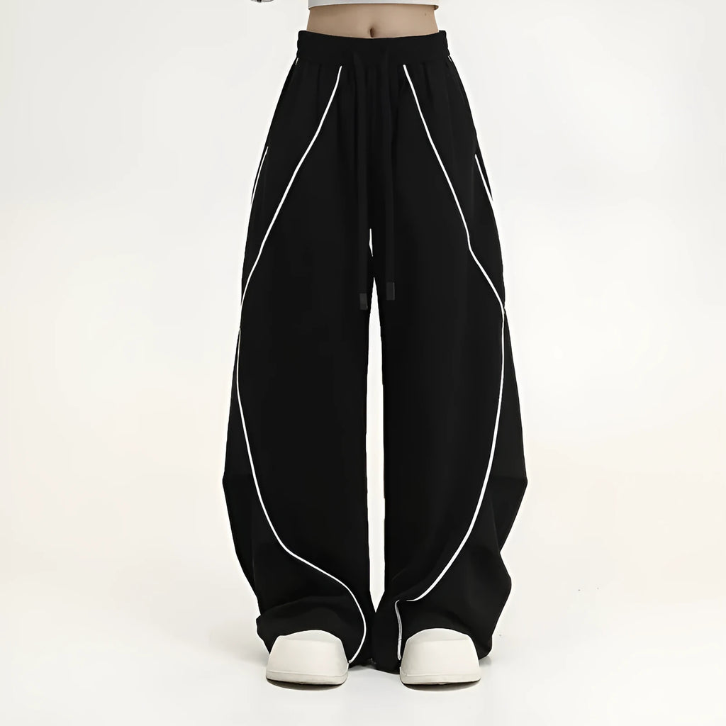 Black and white striped pleated wide-leg hip hop sports pants on a mannequin, showing loose fit and mid waist.