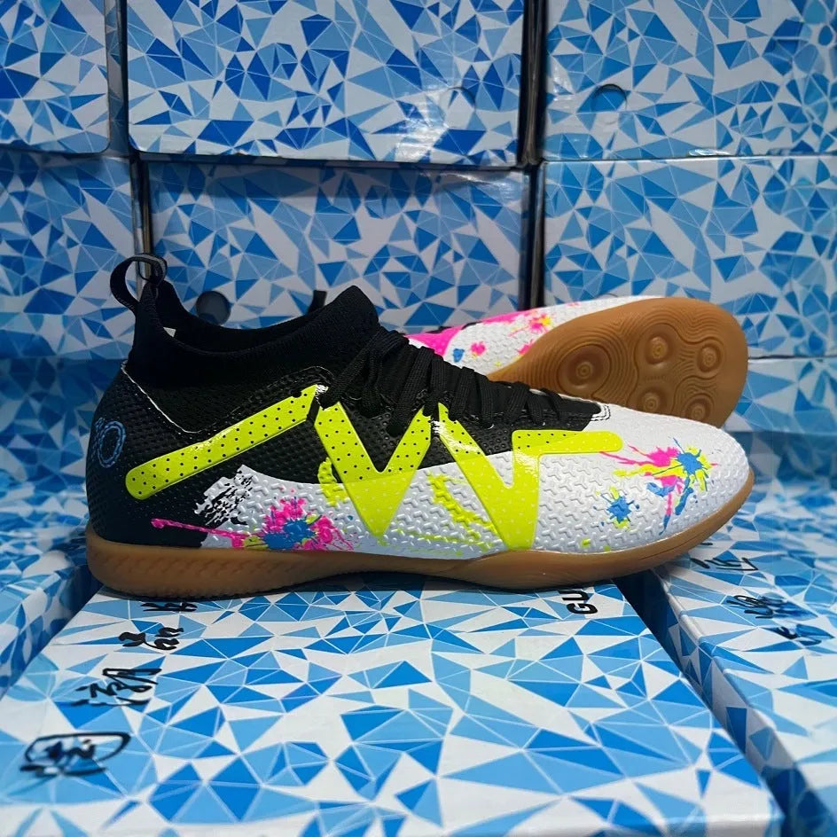 Low-top soccer boots in black and yellow colourway with spiked rubber sole, shown on a firm ground surface.