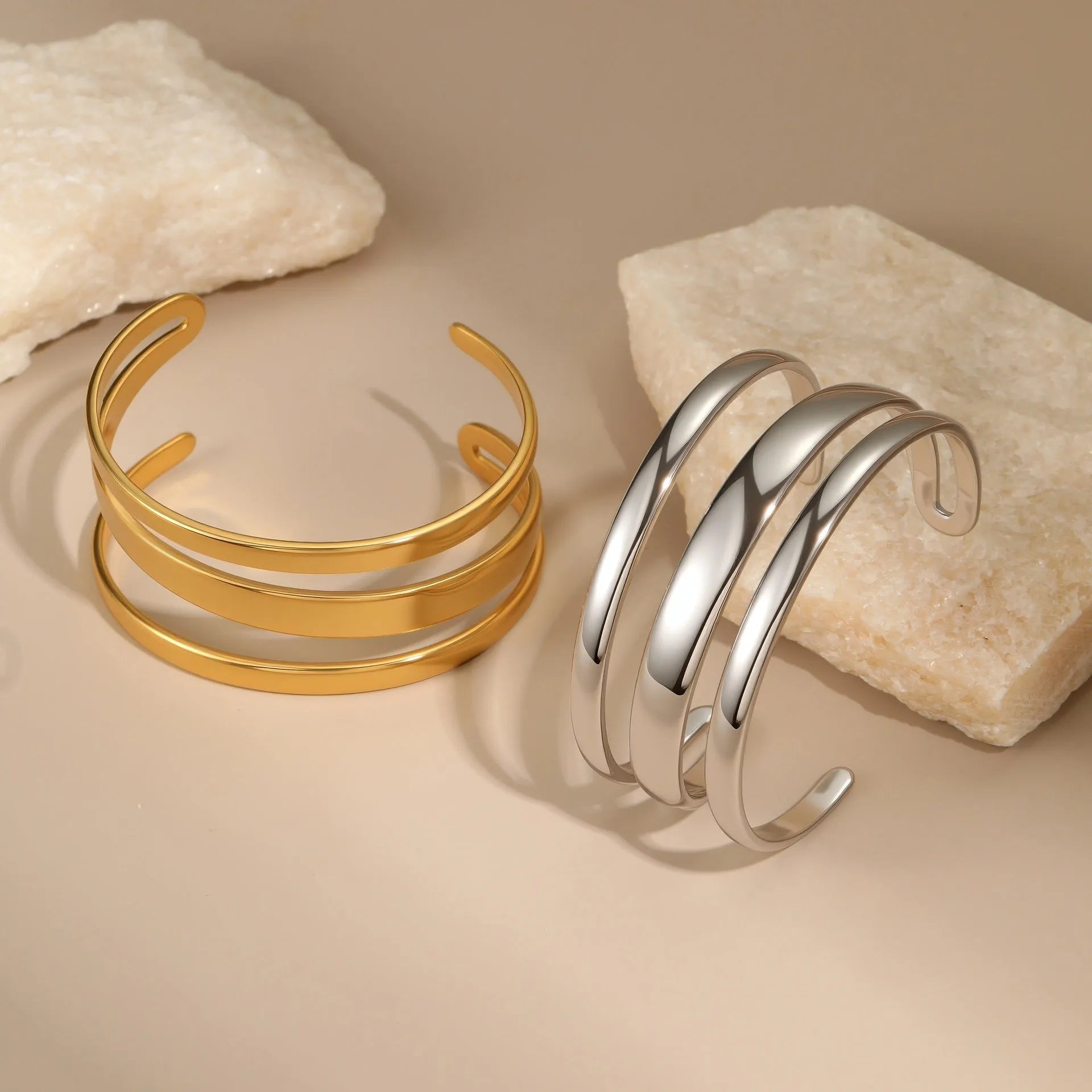 Women's stainless steel bracelet with geometric line design, shown in gold and steel finish options.